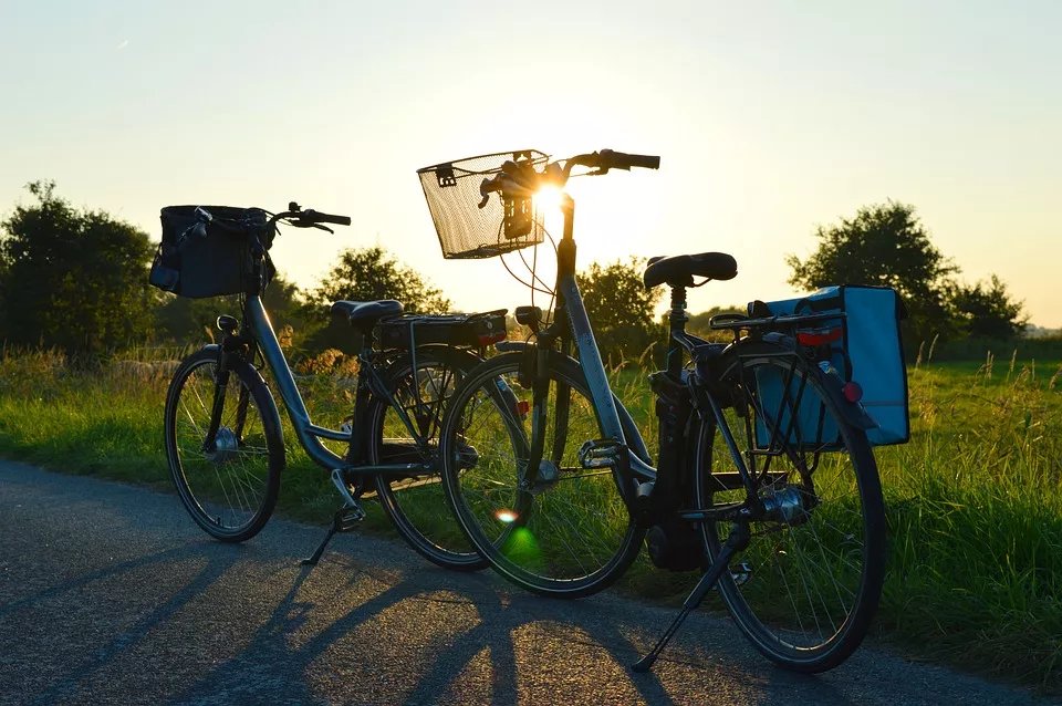 Zwei Fahrräder mit Gepäcktaschen am Wegesrand im Sonnenuntergang