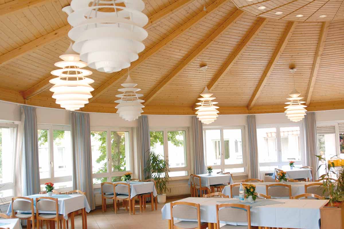 Speisesaal im Haus Elisabeth mit Holzdecke und langer abgerundeter Fensterseite